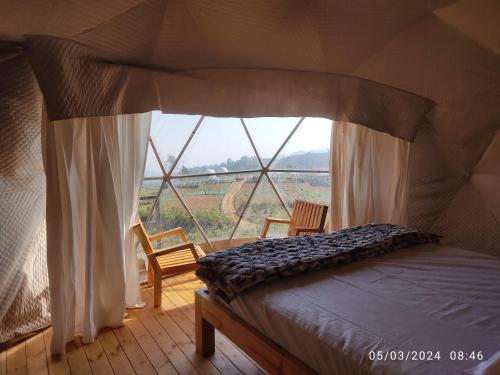 科代卡纳尔Kodai Glamp的一张位于带大窗户的帐篷内的床铺