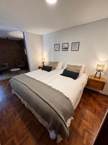 门多萨CASA ALMA LUXURY HOME的一间卧室配有一张带两盏灯的大型白色床。