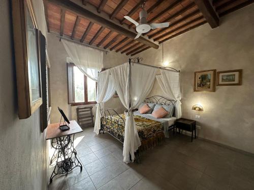 比萨-- Il Casale Toscano -- 1700mt dalla Torre di Pisa, ONLY RENTS ROOMS WITHOUT BREAKFAST, FREE PARKING, POSSIBILITÀ DI SELF CHECK-IN DALLE 15的一间卧室设有天蓬床和天花板