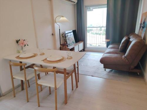 曼谷2BR, 6 Mins walk BTS Wuttakat的客厅配有桌子和沙发