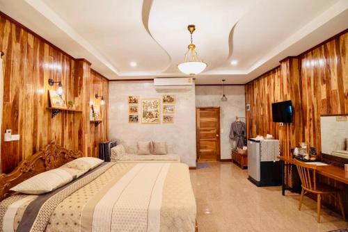 Ban Tha Changชนบท เขาใหญ่的一间卧室配有一张床、一张书桌和一台电视