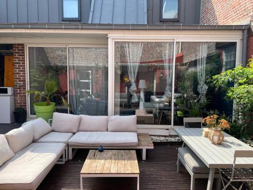 里尔Studio indépendant et calme avec Jacuzzi à Lille的客厅设有白色沙发,位于庭院