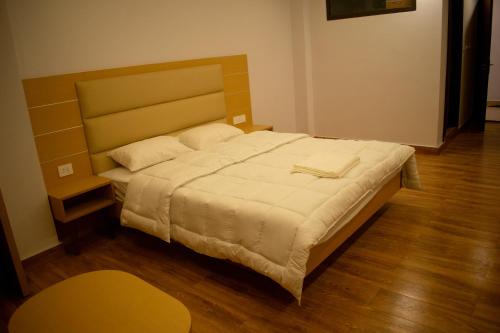 甘托克The Grand ARK的一间卧室设有一张大床,铺有木地板