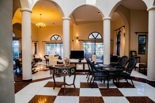 基利菲Amani House的大堂设有椅子和桌子,位于客房内