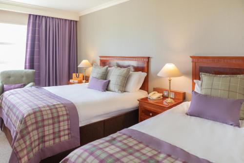 特里姆奈克斯布鲁科高尔夫度假酒店的酒店客房,配有两张床和椅子