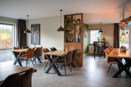 Loon op ZandHotel B&B Buiten Loon的用餐室配有木桌和椅子
