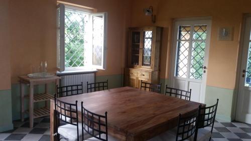 Rocchetta TanaroCascina Rollone的一间带木桌和椅子的用餐室