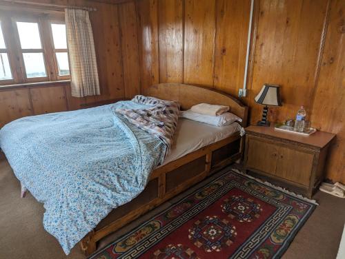 LuklaLukla Himalaya Lodge的木制客房内的一间卧室,配有一张床