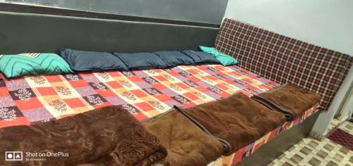 乌贾因Gehelot DharmShala的床上有被子和枕头