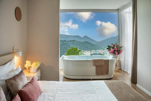 罗塔迪马尼亚Rota Apartments的一间山景卧室,配有浴缸