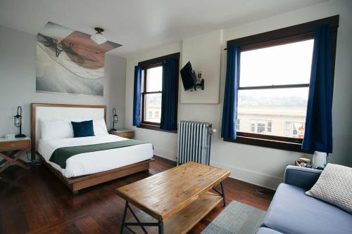 阿斯托里亚Commodore Hotel的一间卧室配有一张床、一张桌子和一张沙发