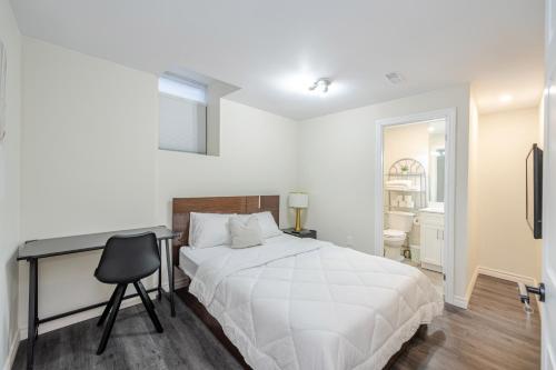 奥克维尔Private basement bedrooms in Oakville的一间卧室配有一张床、一张桌子和一把椅子