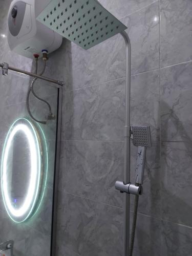 拉各斯Soulmate Hotels & Suites的浴室内配有带镜子和灯的淋浴