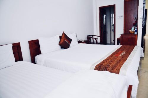 岘港Quốc Khánh Hotel Da Nang的卧室内两张并排的床