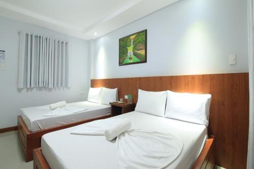 BalateroOrient De Galera Beach Resort的酒店客房,配有两张带白色床单的床