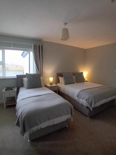 杜林Fairwinds Guest Accommodation的一间卧室设有两张床和窗户。