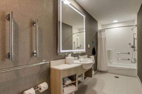 斯蒂尔沃特SpringHill Suites by Marriott Stillwater的一间带水槽、镜子和淋浴的浴室