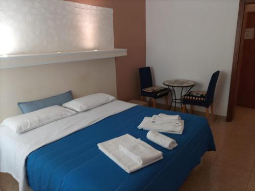 莱切H Central Lecce的一间卧室配有蓝色的床和毛巾