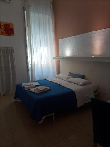 莱切H Central Lecce的一间卧室配有一张带蓝色毯子的大床