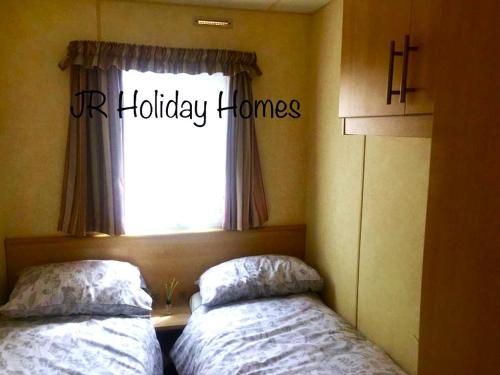 滨海克拉克顿J.R. Holiday Homes的卧室在窗户前配有两张床