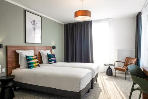 阿斯克新城The Originals Residence, Le Wax, Lille Est的酒店客房设有两张床和窗户。