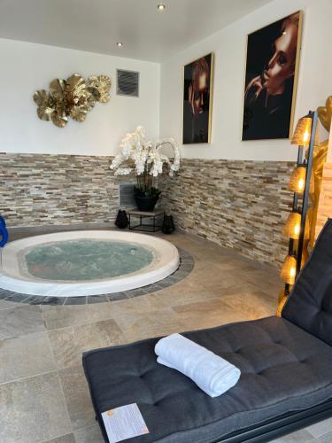 Sains-du-NordLe Domaine des Fagnes的带沙发的客房内的按摩浴缸