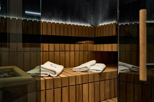 蒂罗尔-泽费尔德Bergkranz Apartments的木制架子上带白色毛巾的桑拿浴室