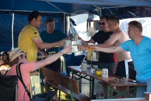 施皮尔贝格Ring Rast Camping的一群男人站在桌子旁喝着饮料