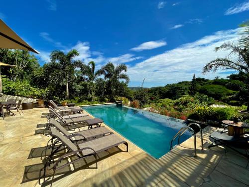 布希奥斯Pousada Villa Canaã的庭院内一个带躺椅的游泳池