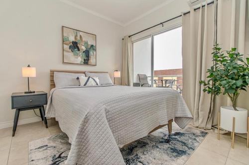 金斯敦Luxury DreamCondo Bromptons的白色的卧室设有床和大窗户