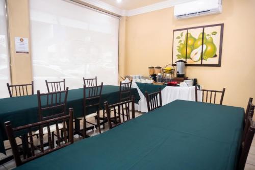 伊达尔戈州波萨里卡Hotel Du Parc的一间带绿色桌椅的用餐室