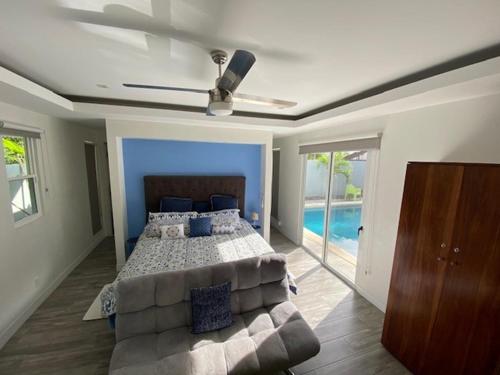 瓜纳卡斯特Playa Potrero - modern 3 BR home centrally located - Casa Coastal Serenity的一间卧室配有一张床、一张沙发和吊扇。