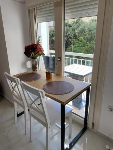 卡瓦拉White Apartment的餐桌、两把椅子和窗户
