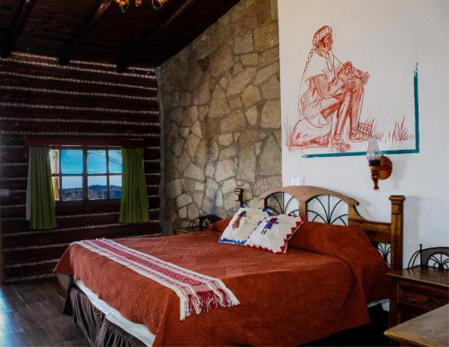 埃尔迪维萨德罗迪维萨德罗巴兰卡斯酒店的一间卧室设有一张床和石墙