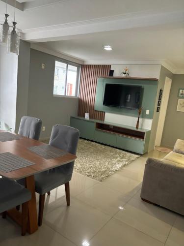 圣路易斯Belíssimo apartamento a 01 km da litorânea的客厅配有餐桌和电视