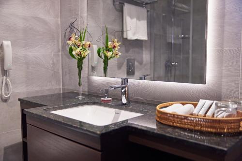 帕拉马里博Yogh Hospitality的浴室设有水槽、镜子和鲜花