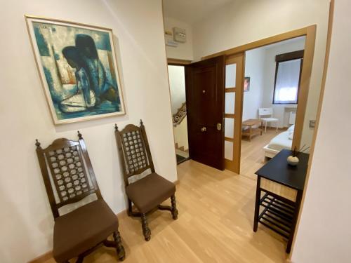 拉斯特雷斯Apartamento Mar Bella的客厅配有两把椅子和墙上的绘画