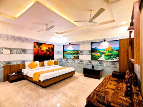 萨三吉尔Hotel Anil Farmhouse Gir Jungle Resort的一间卧室设有一张大床,墙上挂有绘画作品
