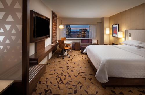 西雅图Sheraton Grand Seattle的酒店客房,配有床和电视