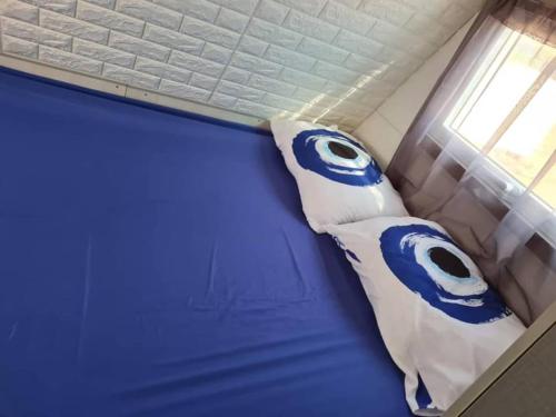 埃拉特שאשא קראון的一张带蓝色和白色枕头的床
