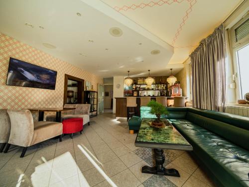 摩拉瓦托普利采Hotel Maj Inn的客厅配有绿色沙发和桌子
