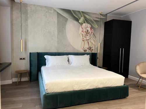 米兰The Unique Hotel的一间卧室配有一张大床和绿色床头板