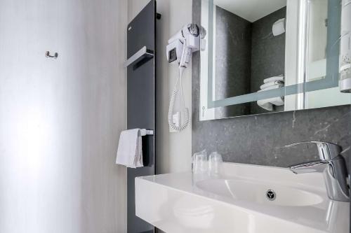 阿纳齐Brit Hotel Le Cottage Le Mans Sud的白色的浴室设有水槽和镜子
