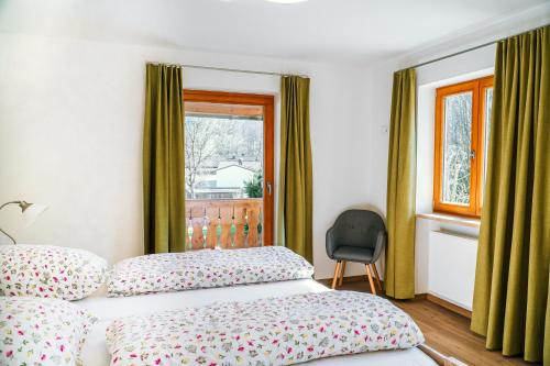 巴特莱辛哈尔Ferienwohnungen Quellenhof的一间卧室设有一张床、一个窗口和一把椅子