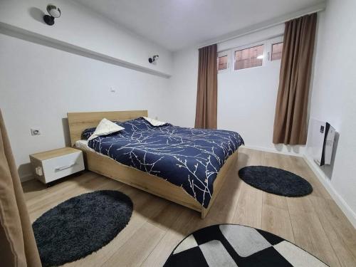 GjakoveApartments Gjakove的卧室配有一张床,地板上铺有2个地毯。