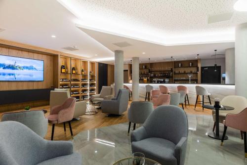 蒂艾Brit Hotel Paris Orly Rungis的一间设有桌椅和电视的等候室