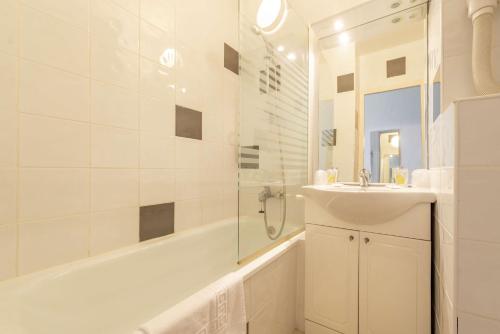 卡斯特尔Brit Hotel Confort Castres的白色的浴室设有水槽和浴缸。