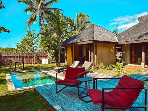 Tohautu米提拉帕别墅酒店的游泳池旁带红色椅子的庭院