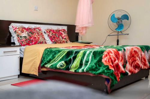 利隆圭Moments Lodge的一间卧室配有一张带绿色和红色毯子的床