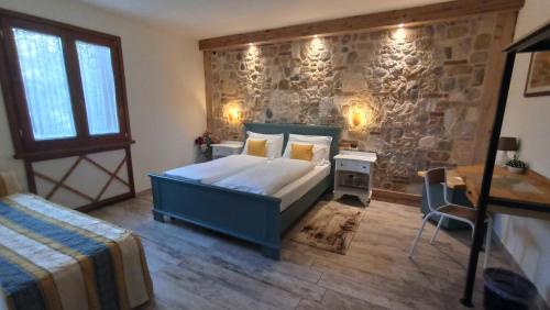 科拉迪拉齐塞Le Zampolle B & B的一间卧室设有一张床和石墙